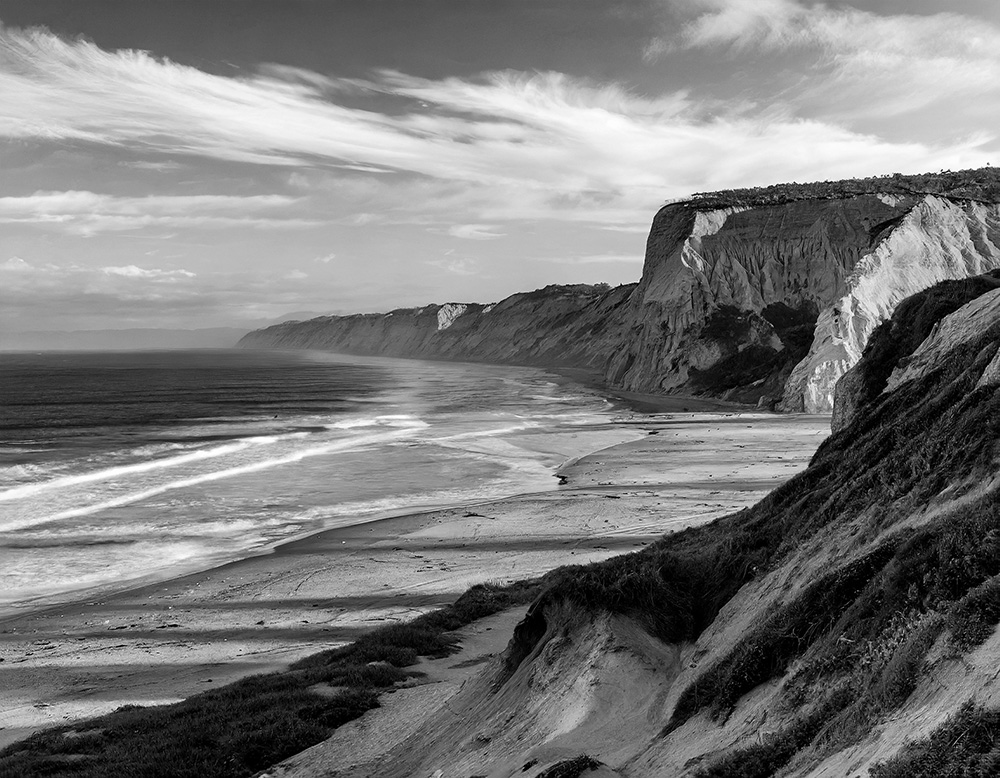Long beach, tall cliffs on right, blue hour